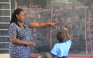 A TSC Teacher assisting a learner in working out mathematics activities in a school in Northern Kenya 