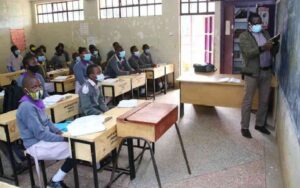 A primary school tsc teacher attending to learners in a school in Nairobi