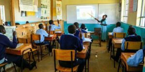 A primary school teacher attending to learners at a school in Eastern Kenya 